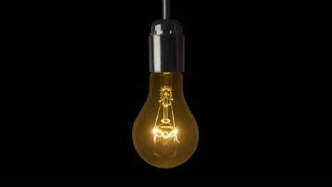 Swinging light bulb a black background Stock Footage 86076729