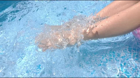 Swinging our feet in clear water in the pool Видео 157449615