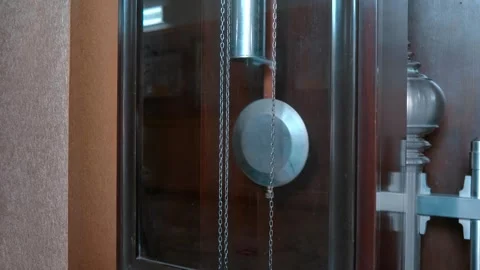 Swinging pendulum and metal weights and silver round dial of grandfather clock Stock Footage 308863623