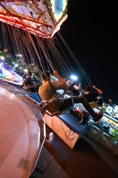 Swinging in theme park at fully lights night Stock Photos