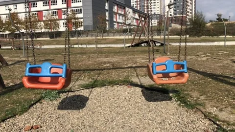 Swinging two empty swings in the playground Stock Footage 221196328