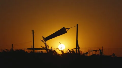 Swinging wind sock, Wind indicator at sunset. Weather forecast, information Stock Footage 245701950