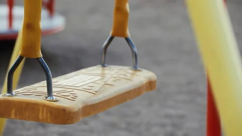 Swinging Yellow Childrens Swing on an Empty Playground Stock Footage 157208110