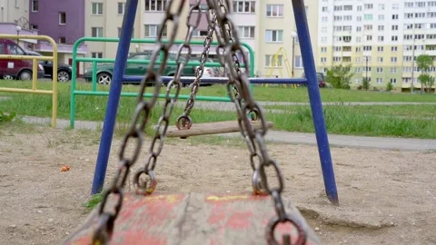 Swings with rusty chains and peeling paint waved by wind Stock Footage 134998959