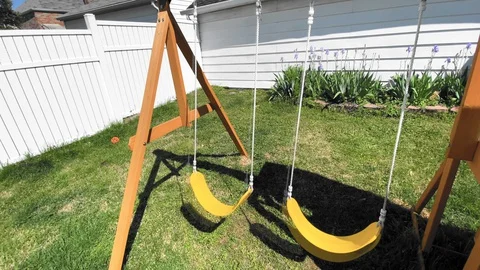 Swings sway back and forth on an empty swing set Stock-Footage 129469584