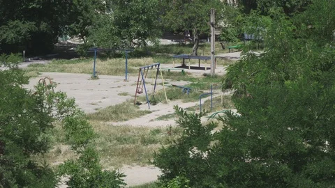 Swings swinging on a large empty playground in the yard Stock Footage 110799225
