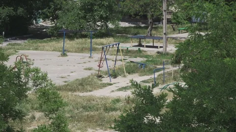 Swings swinging on a large empty playground in the yard closeup Stock Footage 110799240