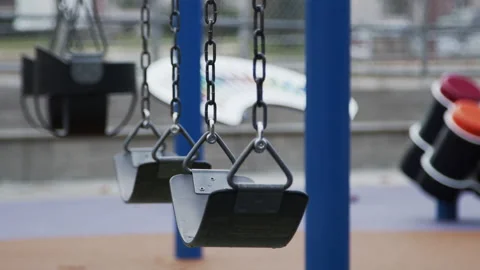 Swingset in Empty Playground After Rain Covid 19 Lockdown Focus Pull Stock Footage 147561024