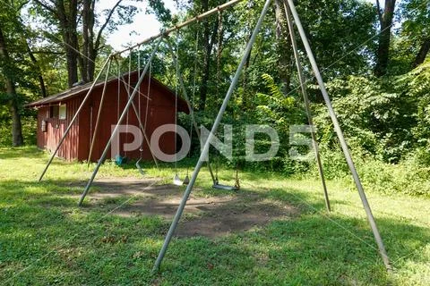 Swingset at summer camp with a broken swing. Stock Photos
