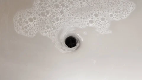 Swirl of foamy water falling down the drainage hole Stock Footage 129326863