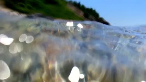Swirling bubbles blur through blue seawater, shaped by active waves that form Stock Footage 314937693