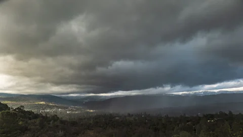 Swirling Clouds and Rain Squallls Engulf Mountain Valley Time Lapse Stock Footage 280249995