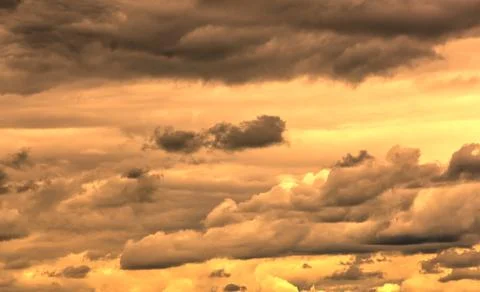 Swirling clouds illuminated by the setting sun Stock Photos