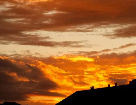 Swirling clouds illuminated by the setting sun Stock Photos