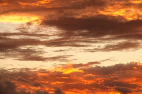 Swirling evening clouds illuminated by the setting sun Stock Photos