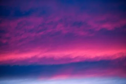 Swirling evening clouds illuminated by the setting sun Foto stock