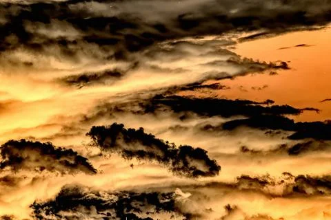 Swirling evening clouds illuminated by the setting sun Stock Photos