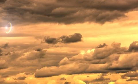 Swirling evening clouds illuminated by the setting sun Stock Photos