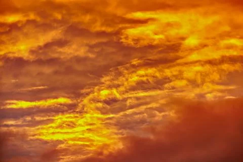 Swirling evening clouds illuminated by the setting sun Stock Photos
