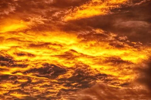 Swirling evening clouds illuminated by the setting sun Stock Photos