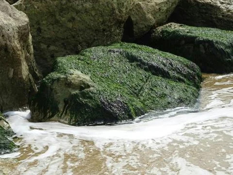 Swirling Ocean Waves Next To Rocks Stock Photos