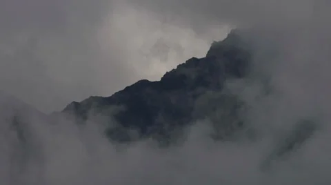 Swirling Spectral Cloudy Mists on Rugged Rocky Cliff Time Lapse Video stock 36640100