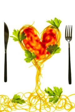 Swirls of cooked spaghetti with fork. Spaghetti heart shape. Stock Photos