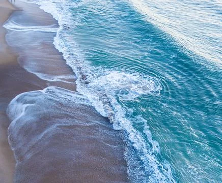 Swirls in the surf left by the waves Stock Photos