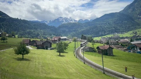 Swiss Countryside Train Passing Through Lush Green Valley – 24 June 2024 Stock Footage 306014624
