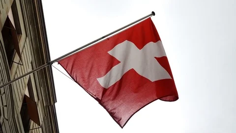 Swiss flag waves in the wind from a Building- slow motion Stock Footage 76890898