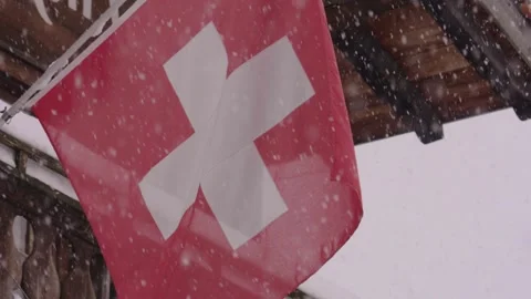 Swiss flag waving during a winter snowfall in the alps Vídeos de archivo 330284488