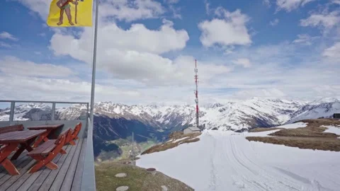Swiss flag waving on mountain top restaurant Stock Footage 310077446
