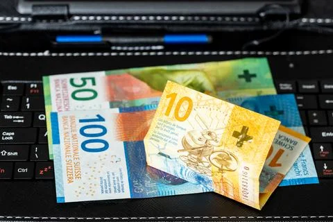 Swiss francs lying on a tablet keyboard, business e-commerce in Switzerland Stock Photos