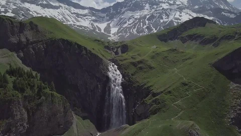 Swiss waterfall surrounded by mountains covered with snow Stockbeeldmateriaal 123711045