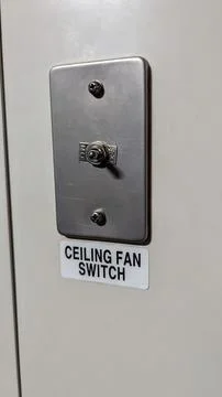 Switch for controlling the ceiling fan located on a wall in a residential o.. Stock Photos