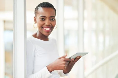 Switch to mobile tech and get more done. a young businesswoman using a digital Stock Photos