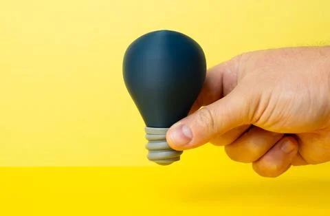 The switched off light bulb is an idea in the hand. Startup incubator. Spar.. Stock Photos