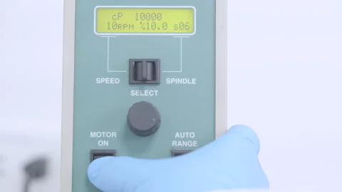 Switching on and adjusting a digital viscometer while wearing a protective glove Stock Footage 340336156