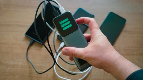 Switching charging indicators on powerful power bank while charging three Stock Footage 337879952