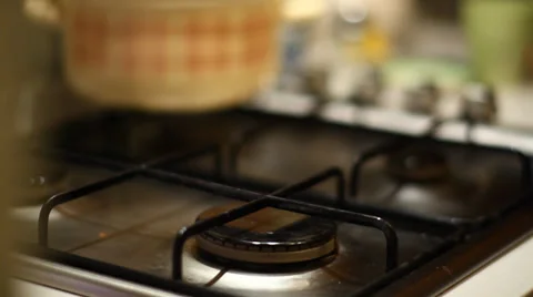 Switching on gas and placing stainless steel pot on gas oven Stock Footage 34034623