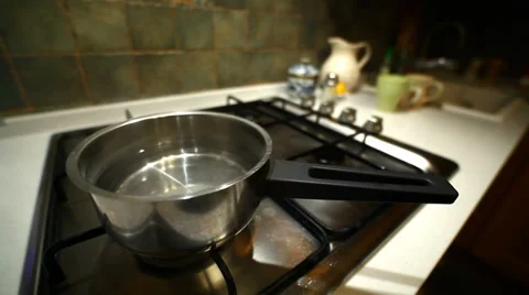 Switching off gas and taking stainless steel pot off gas oven Stock Footage 34031724