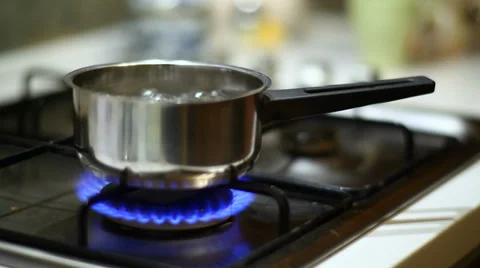 Switching off gas and taking stainless steel pot off gas oven Stock Footage 34033991