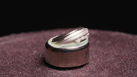 Swollen Exploded Battery with Broken Metal Cap in Macro Loop Rotation Shot on Da Video stock 324559631