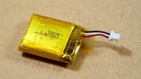 Swollen lithium-ion pouch battery with three-wire connector and thermistor .. Stock Footage 339372882