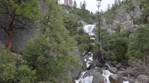 A swollen spring river crashes over rocks in Yosemite Stock Footage 62631433