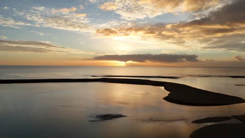 Swooping to low flight along beach to sunrise Stock Footage 320833732
