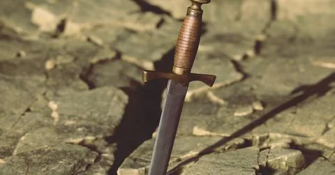 Sword embedded in rocky ground symbolizes strength and determination in natur Stock Illustration