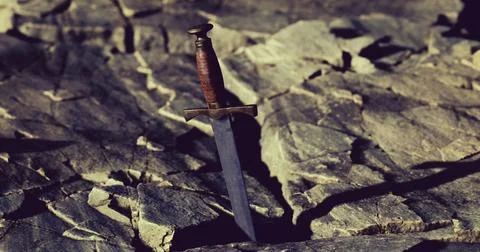 Sword embedded in rocky terrain under natural light conditions Stock Illustration