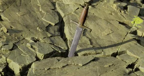 Sword embedded in rugged rock formation at outdoor location Illustration