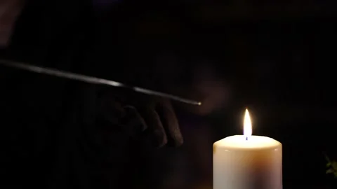 Sword glows over the flame of a wax candle 스톡 동영상 133077212